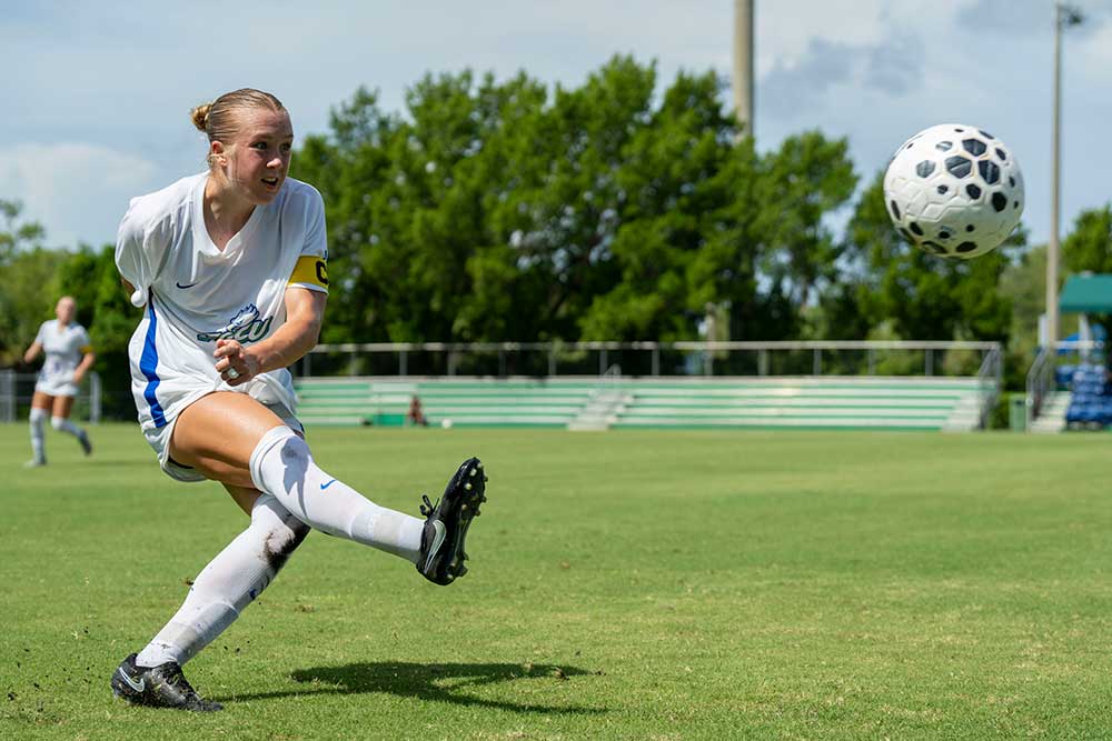 FGCU defender kicks the ball during a women's soccer match