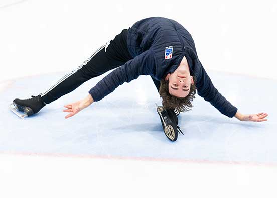 Figure skater demonstrates flexibility move during ice practice