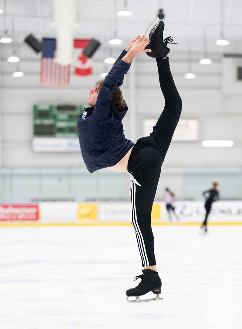 Figure skater performs Biellmann position during ice training