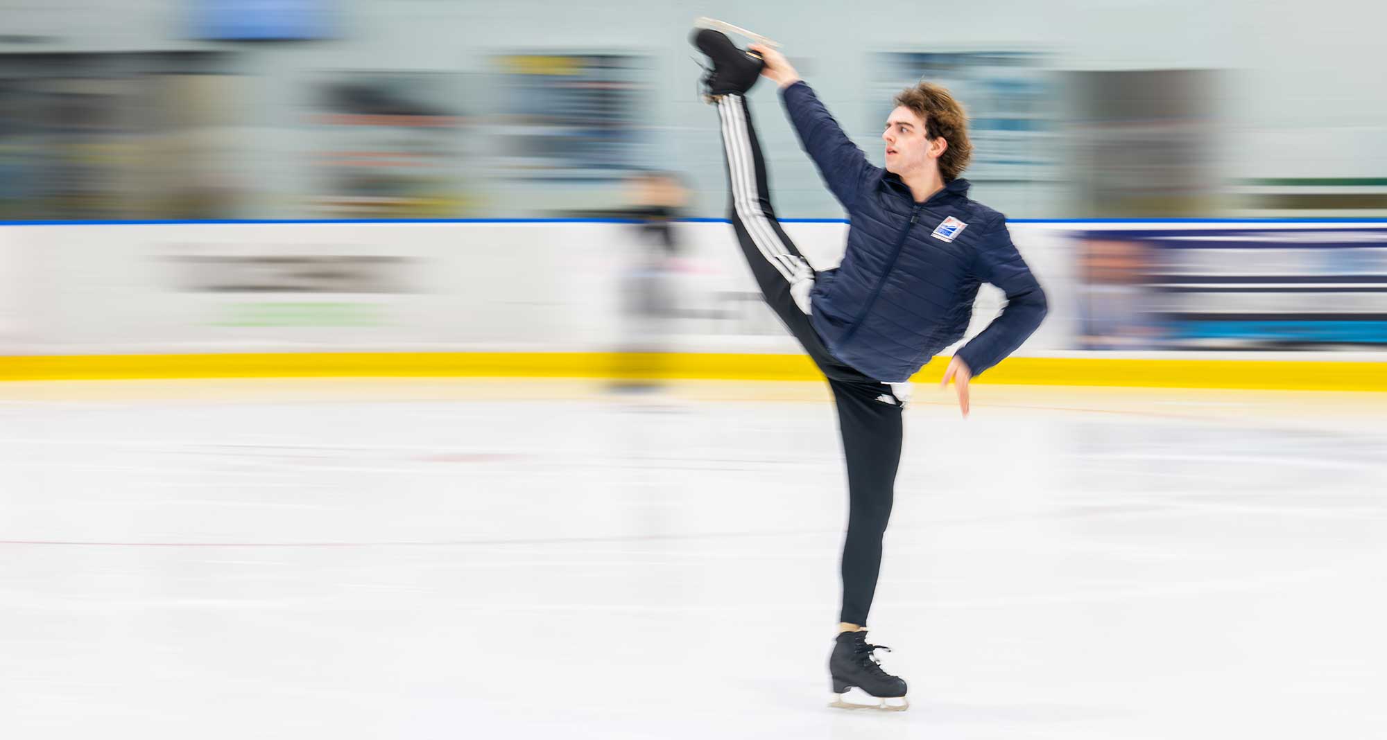 Figure skater demonstrates flexibility move during ice practice